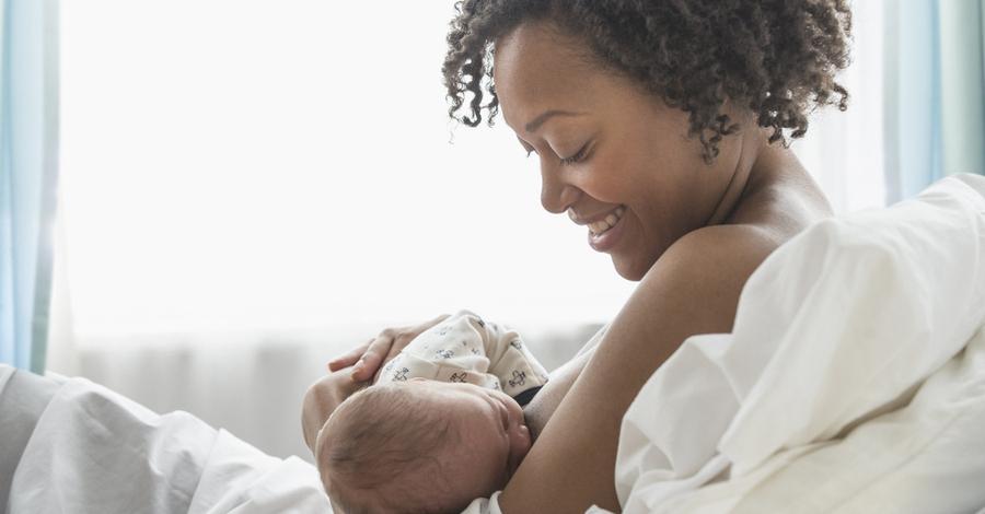 Mixed race mother nursing newborn baby